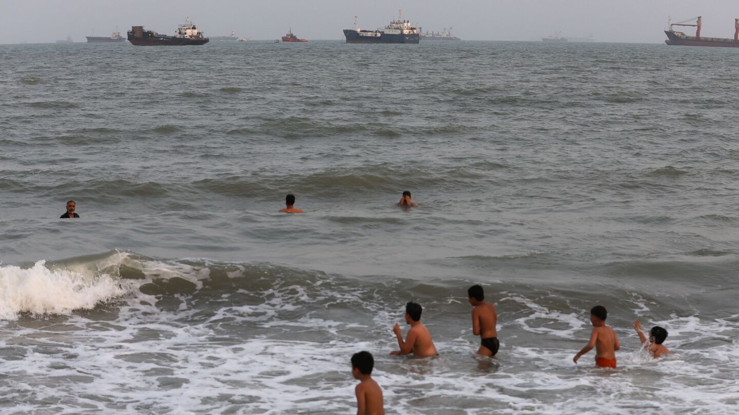 Children swim as ships are seen anchored in the Strait of Hormuz on Aug. 10 off the coast of Bandar Abbas, Iran. Photo by Ali Saeedi / Getty Images